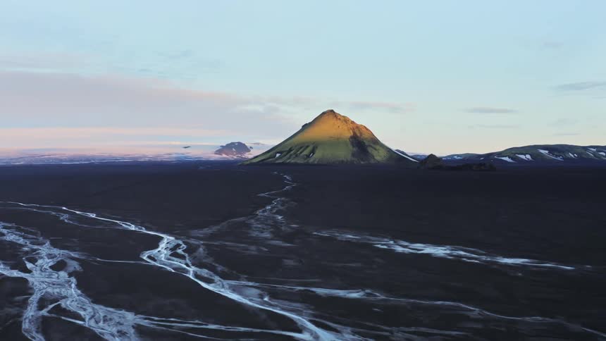 Aerial panorama of a volcano amidst black soil on a winter morning