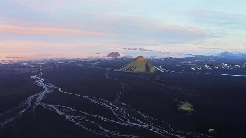 Aerial of a volcanic mountain on a flat terrain near a river