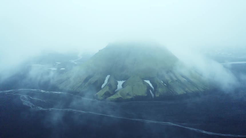 Aerial of a volcano covered by clouds during the day