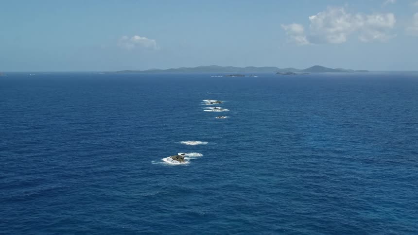Aerial of islets in the ocean during sunny day