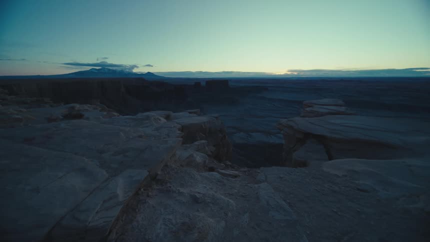 Plateau overlooks arid landscape leading to mountain on the horizon on a cloudy day