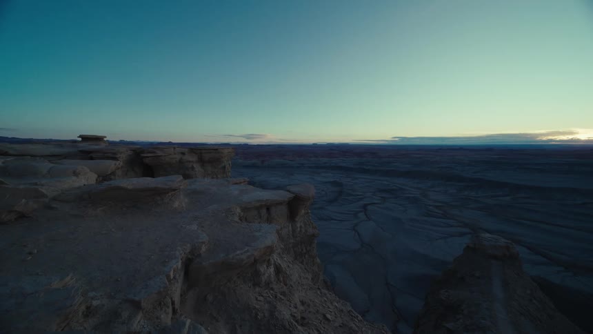 Plateau towers over arid landscape near dusk under light clouds