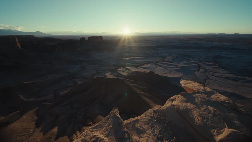 Panorama of a crater amidst a valley with the sunrise on the horizon
