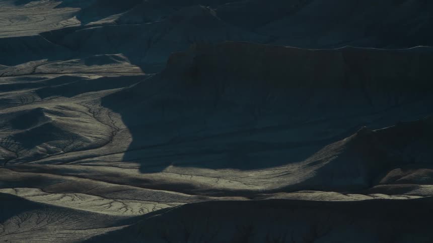 A stretch of rocky desert parcially in shadow