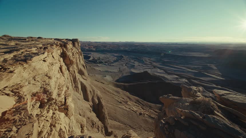Panorama of a cliff with geological valleys under a reflective and blue morning sky