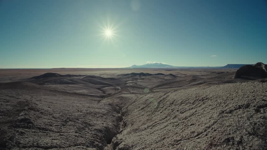 Sun over an area in the desert with hills and valleys