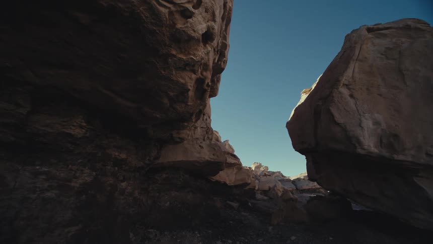 Sun shines onto edge of rock formation forming narrow gap with cliff