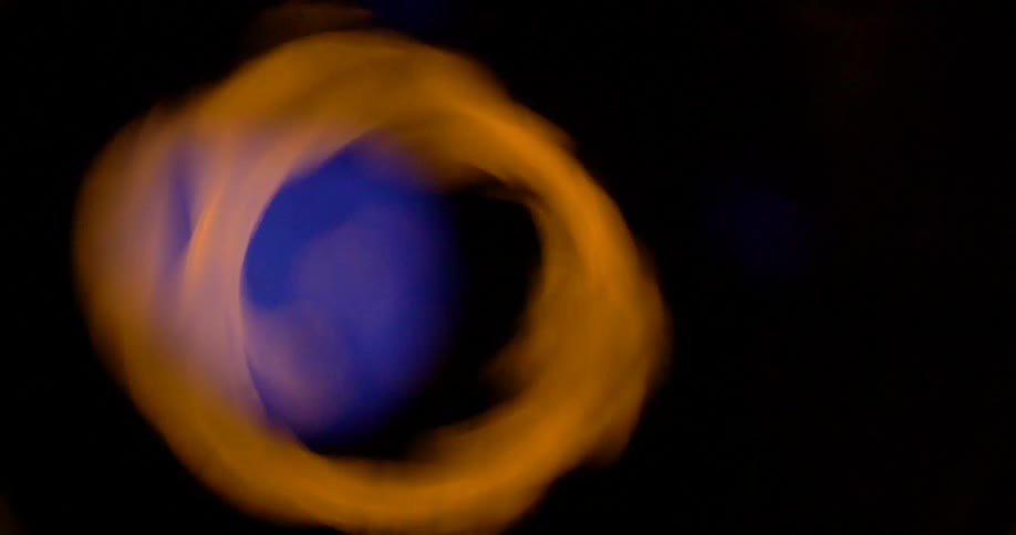 Amber gaseous mixture swirls in darkness