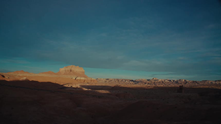 A rocky desert landscape partly in shadow