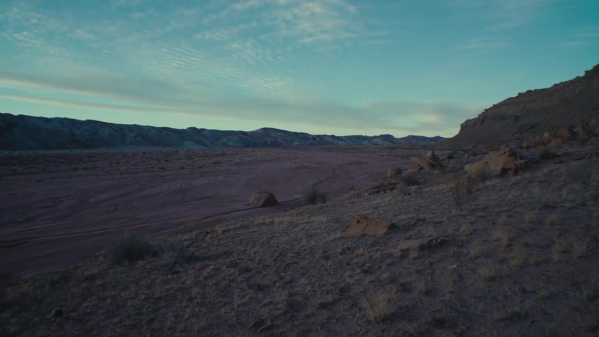 View of a desert terrain with valleys in the background under a morning sky