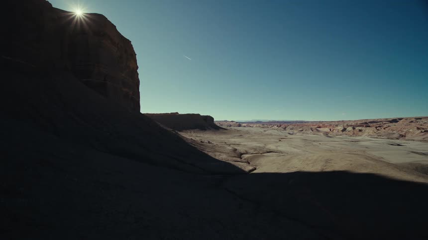 View of a rocky terrain next to a valley with the sun reflecting