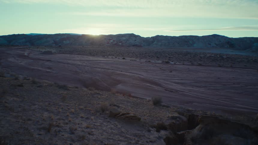 Panoramic view of the sun rising behind the canyons