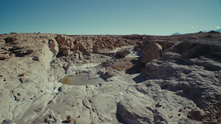 Aerial of a small lake between deserted rocky mountains
