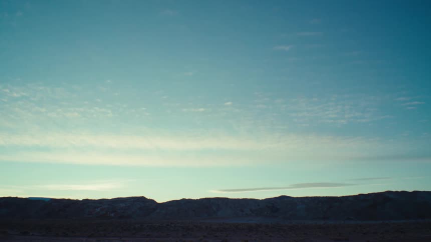 View of a blue dawn sky with a valley on the horizon