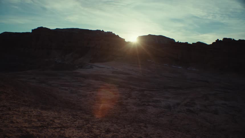 View of the sun passing and reflecting under the beam of a canyon