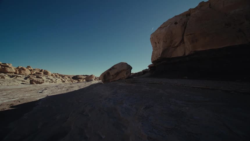 Panorama of a sandy terrain amidst canyons with geological rocks on a day with a blue sky