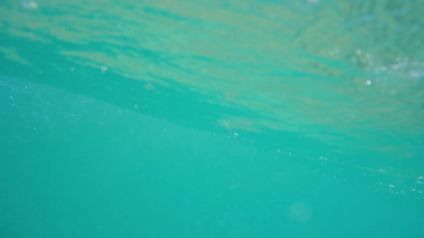 View of a turquoise blue beach wave closing in slow motion