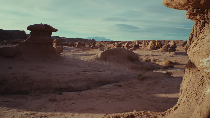 A rocky desert landscape partly in shadow