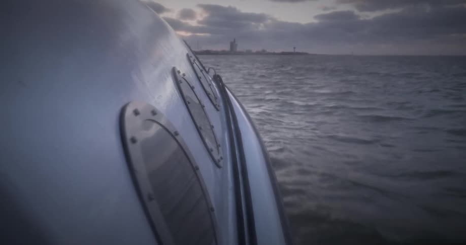 On a cloudy evening a boat ride fast in the ocean towards shore