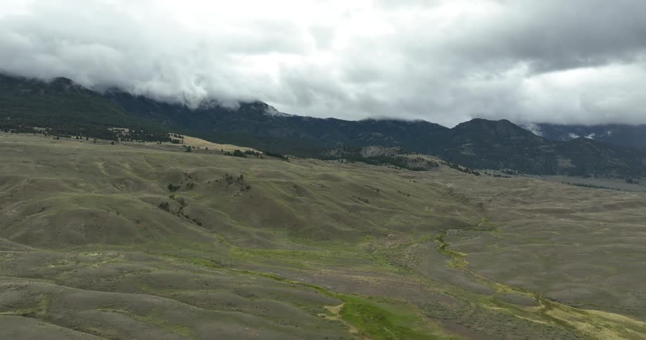 An aerial view of mountains and hills with clouds