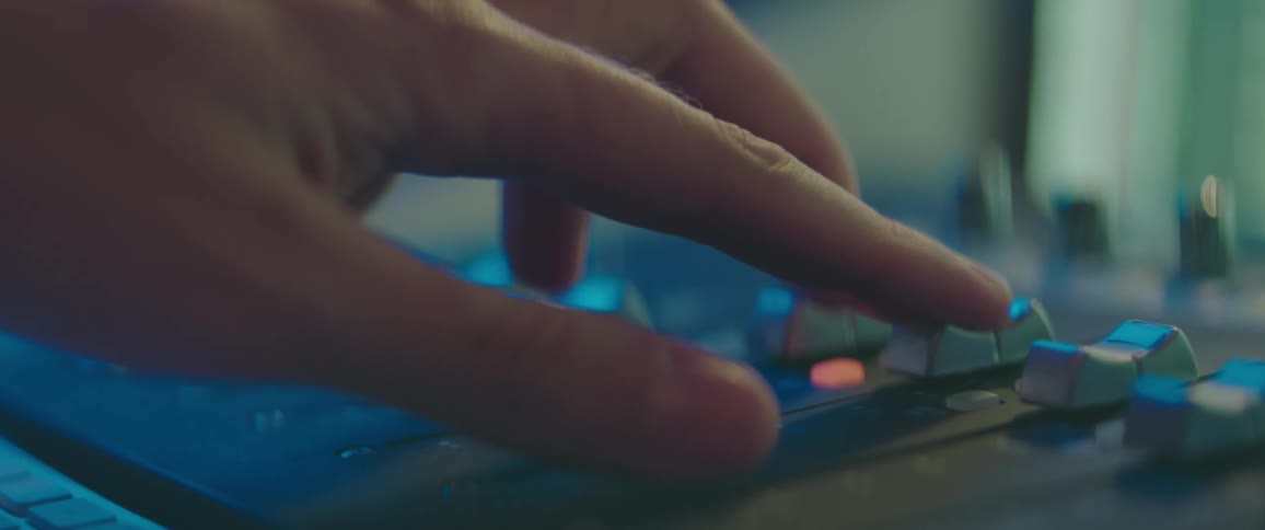 Extreme closeup of a persons hand turning a knob on a mixer