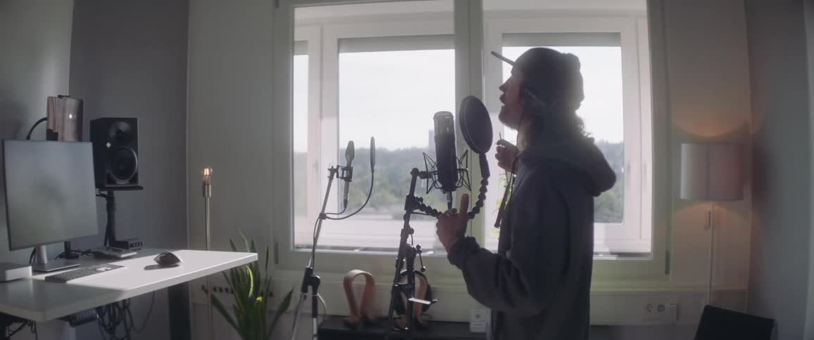 Man inside a room singing in front of the microphone