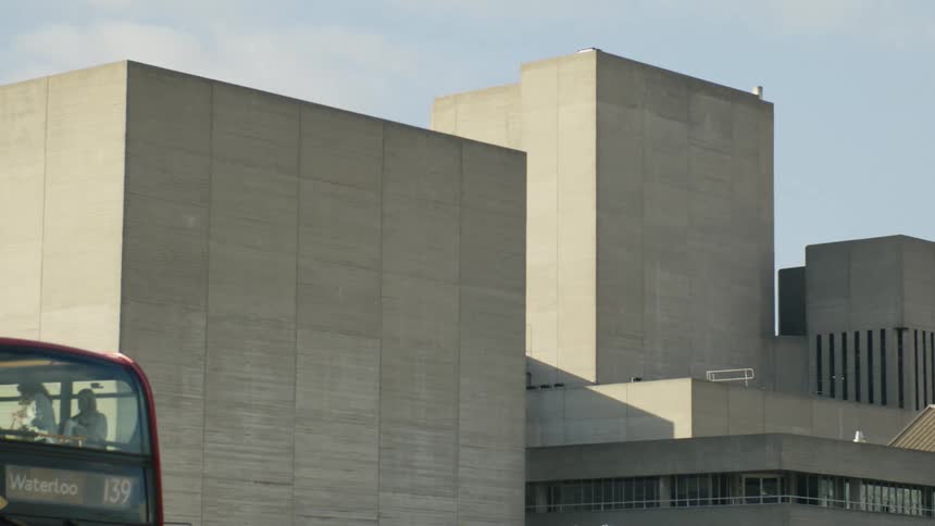 View of the National Theatre in London with a red bus coming to a stop