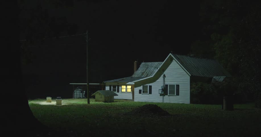 Strong white light hovering over a small house in a rural area at night search helicopter light over hideout