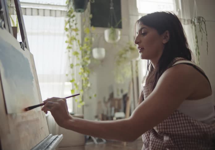 A clip of a lady painting in her room
