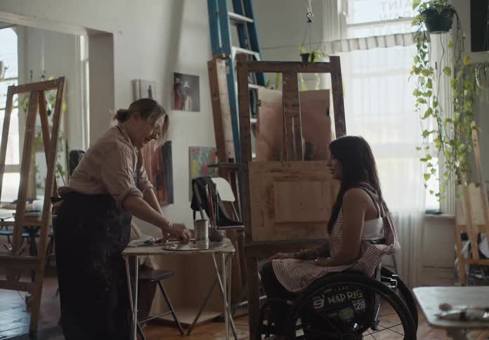 Artist mixing colors over a pallet in a studio