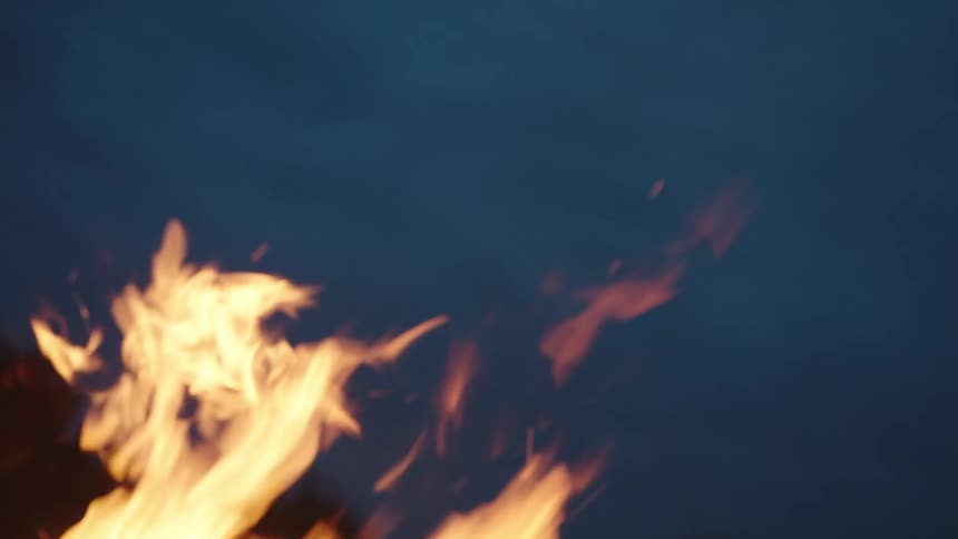 Closeup of fire flickering in the wind on a night