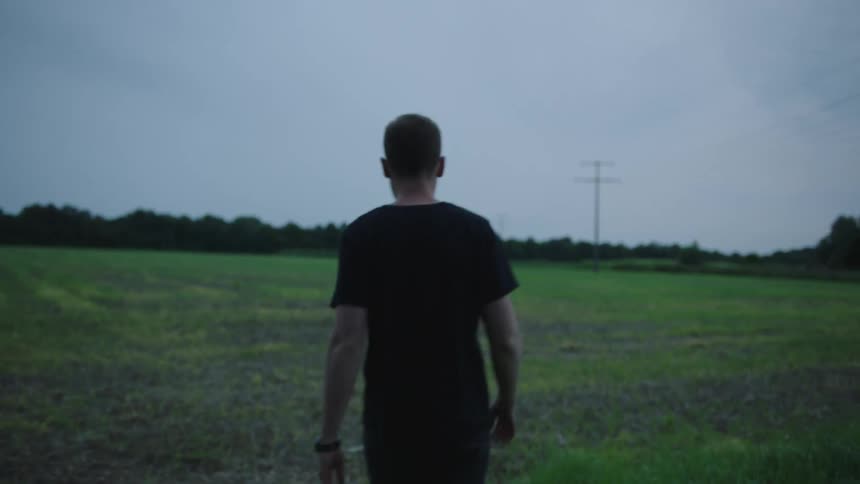 Back view of a man walking through a field