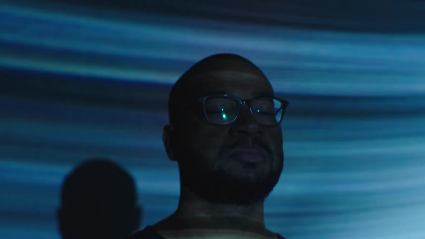 Portrait of a man closing his eyes while a blue light passes over his face