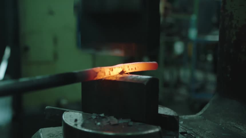 A blacksmith is hammering hot metal