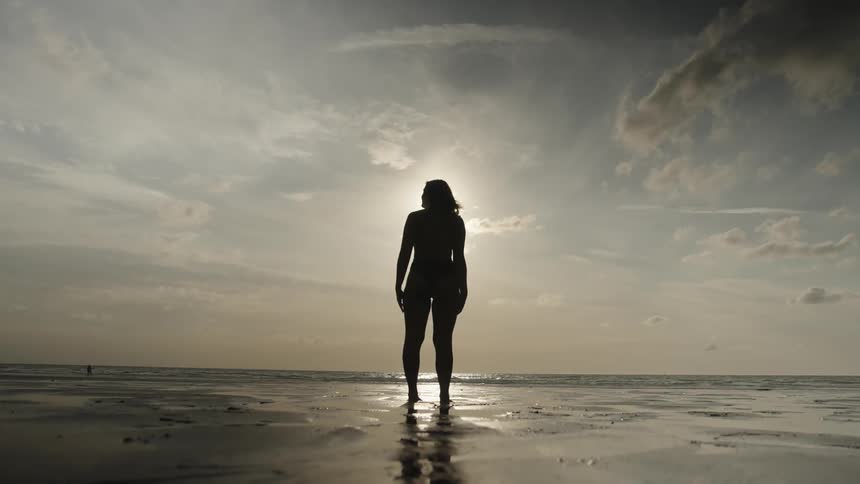 A clip of a female standing by the sea shore