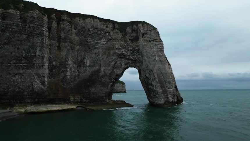 Aerial of a rocky arch on the beach coast during a cloudy day