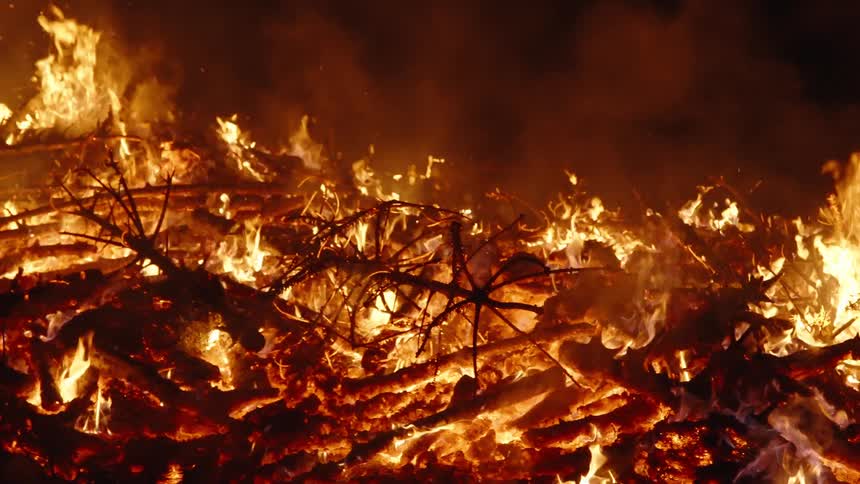 Burning wood at night with fire and smoke coming out in slow motion