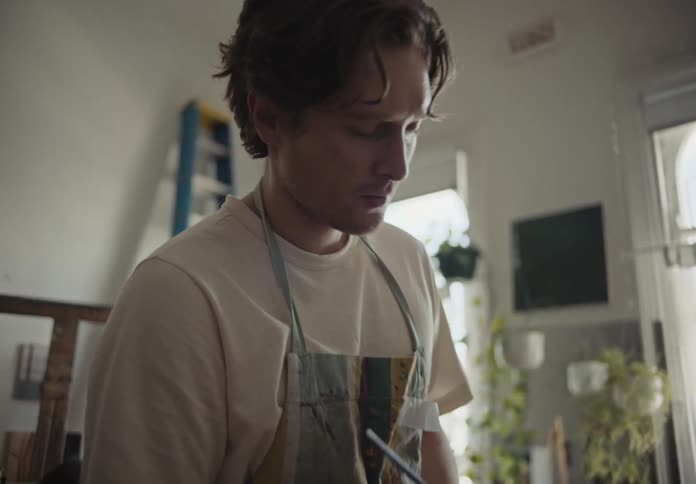 Man painting a canvas inside a room