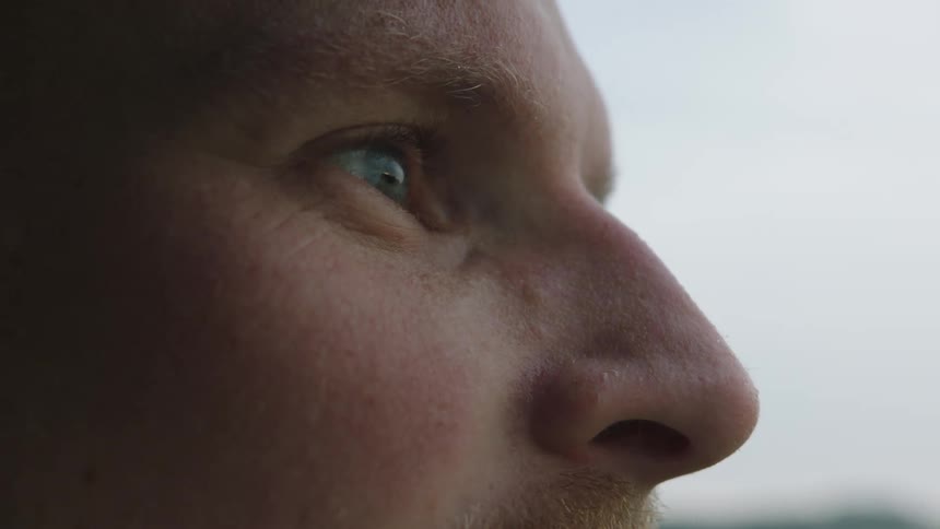 Close up of the profile of a man standing outdoors