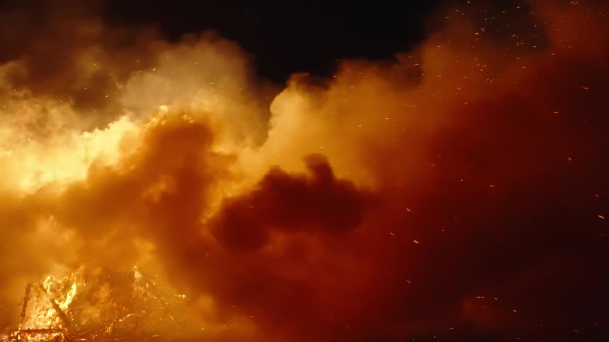 A bonfire with lots of smoke at night outdoors