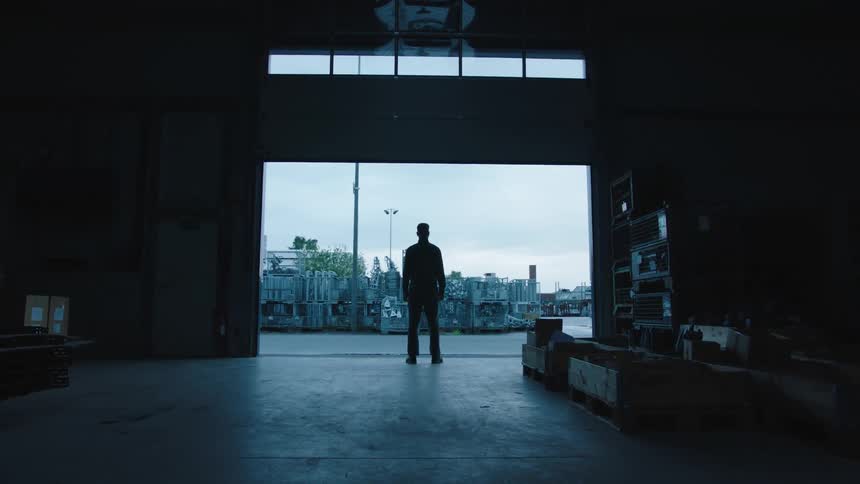 Man inside the establishment observing the city view while the gate is rising