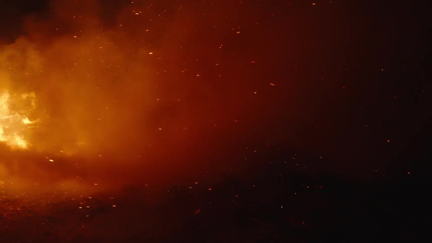 Smoke and glowing embers flying at night