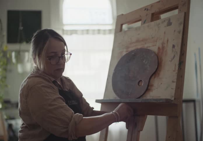 A female setting up a painting canvas in a room
