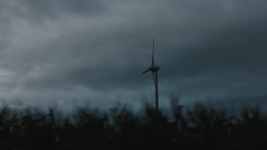 View of a moving wind turbine on a cloudy day