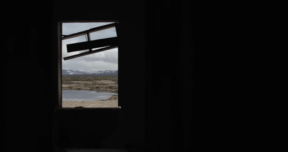 Tattered wood hangs from an empty window