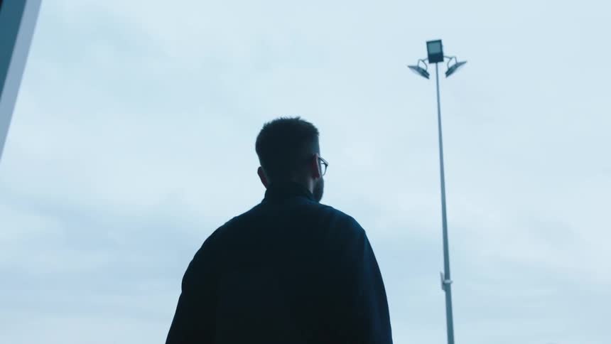 A man walking into a stadium wearing a glass