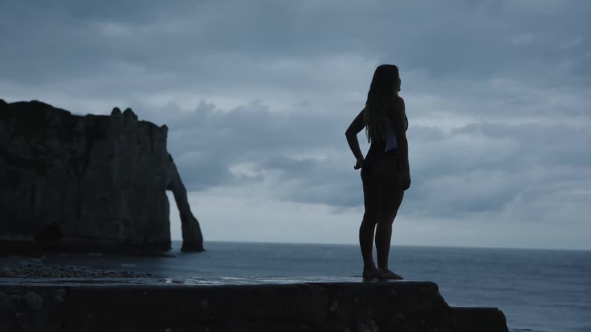 A woman stands on the coast line