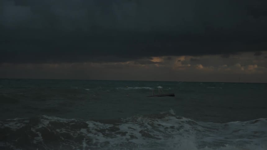 Ship amidst a sea with strong waves on a cloudy day