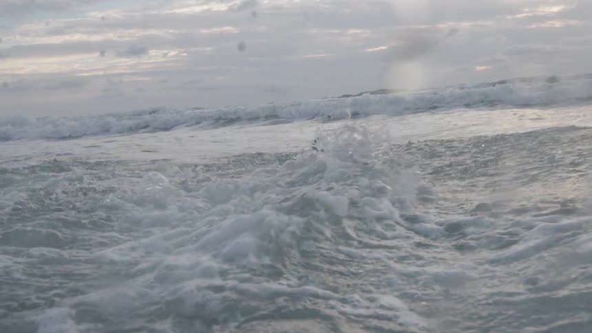 Woman swimming against the tide in the middle of the sea