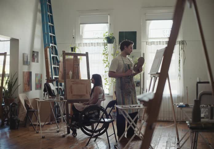 A man turns form painting to talk to a woman